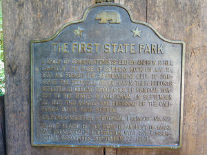 The plaque noting Bog Basin Redwoods State Park's creation as California's first State Park thanks to conservationists who founded Sempervirens Club which in known today as Sempervirens Fund.