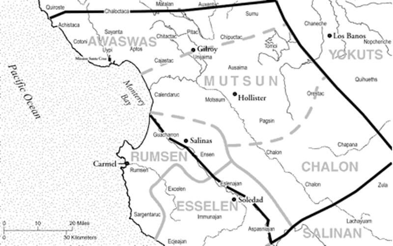 A black and white map of the California Coast – roughly in the Monterey Bay vicinity indicates languages spoken in gray capitalized text as well as the names of Indigenous Peoples who inhabited the areas. The Mutsun ancestral lands are indicated by a gray dashed line extending in a roughly 20 mile radius from Hollister. The Awaswas ancestral lands are to the north, from Gilroy and out to the northern part of Monterey Bay and up along the coast. Map from Amah Mutsun Land Trust.